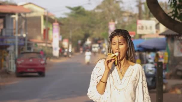 Femme Avec Dreadlocks Mange Une Banane Dans Une Robe Blanche — Video