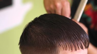 Makas ve tarak ile kuaför genç bir adam için düz püsküller oluşturur. Yüksek kalite 4k görüntü