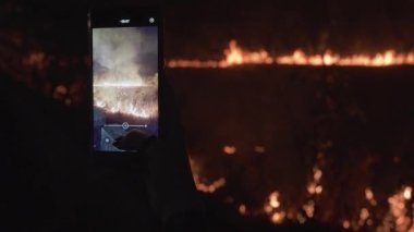 Görgü tanığı cep telefonundaki yangının fotoğraflarını çekiyor. Yüksek kalite 4k görüntü