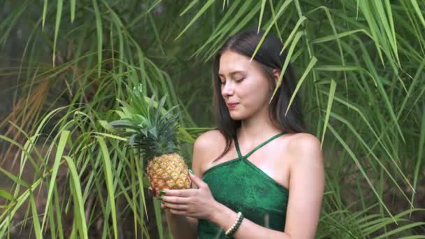 一个年轻的女人在丛林里闻到一种异国情调的菠萝水果的香味 高质量的4K视频镜头 — 图库视频影像