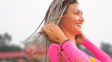 Pembe mayo giymiş, gülümseyen, örgülü bir kadın. Yüksek kalite fotoğraf