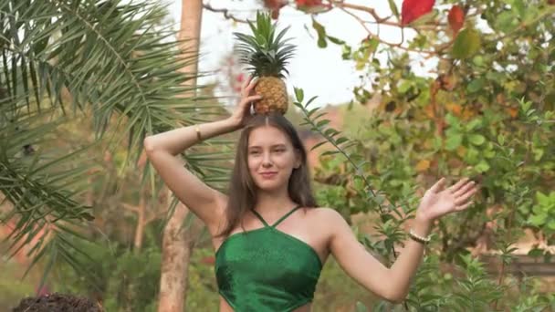 Νεαρή Γυναίκα Πράσινο Μαγιό Που Κρατάει Ανανά Στο Κεφάλι Και — Αρχείο Βίντεο