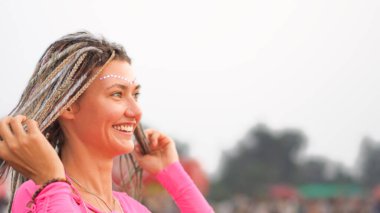 Kafasında örgüler olan genç bir kadın gülümsüyor. Yüksek kalite fotoğraf