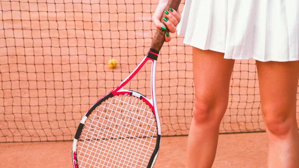 young woman tennis player stands with a racket, closeup. High quality photo