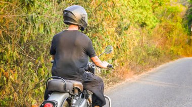 Motosiklet süren genç bir adam tişört giyiyor. Yüksek kalite fotoğraf