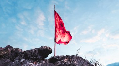 Mavi gökyüzünün arka planında kırmızı bayrak. Yüksek kalite fotoğraf