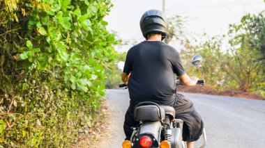 Siyah elbiseli bir adam yolda motosiklet sürüyor. Yüksek kalite fotoğraf