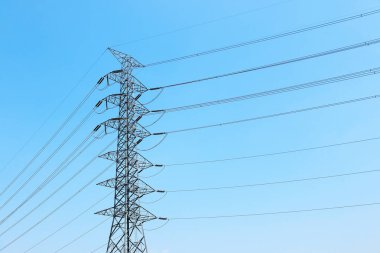 Yüksek voltajlı elektrik direği, kablolar ve mavi gökyüzü..