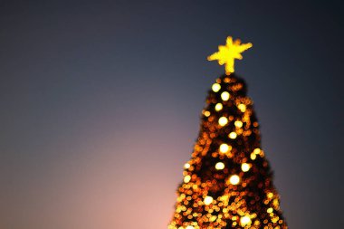 Bulanık Noel ağacı ışıkları alacakaranlıkta ve gecede sallanıyor..