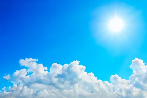 Beyaz bulutlar ve güneşli mavi gökyüzü.