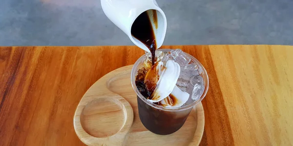 Nalanie Czarnej Lub Ciemnej Kawy Plastikowej Szklance Lodu Świeżymi Kokosami — Zdjęcie stockowe