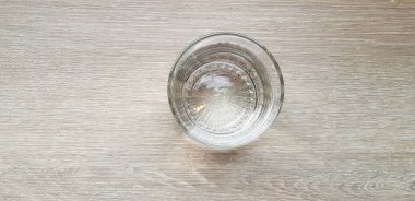 Top view or Flat lay Glass of cold water putting on light brown or gray wooden table for background with copy space. Refreshment, Drink, Object, Clearly and Shinning concept   