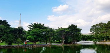 Beautiful green park with lake, tree, white pagoda, clouds and blue sky background. Beautiful in Nature, Relaxing place and Environment in urban city concept