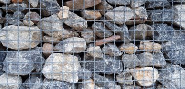 Many rock, stone or limestone in steel netting or net barrier for background. Group of object, Wallpaper and Hard material 