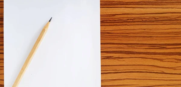 白い紙と茶色の鉛筆は テキストを埋めるためのコピースペースと木製のテーブルに置きます オブジェクトの概念 — ストック写真