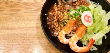 Kaisen Ramen Eriştesi, karides, kızarmış kalamar, kıymalı domuz eti, Çin mantarı Kaisen sosu ahşap masada sol kopya alanı ile birlikte.