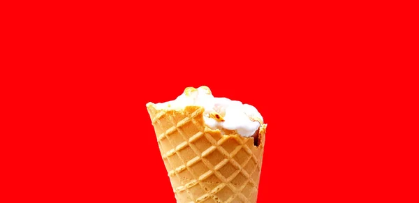 Ice cream cone eaten isolated on red  background. Cold food, Refreshment and Colorful wallpaper concept