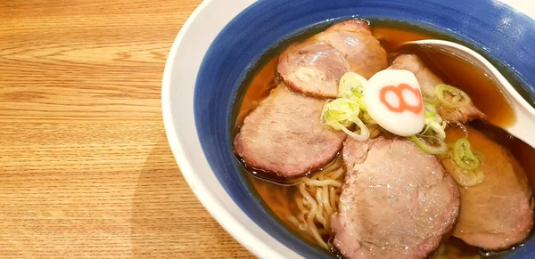 在日本餐馆 用烤猪肉片把火热的哈奇班拉面和美味的汤放在木制桌子上的蓝色碗里 并留有复印空间 健康的生活方式 饮食和亚洲食物概念 — 图库照片