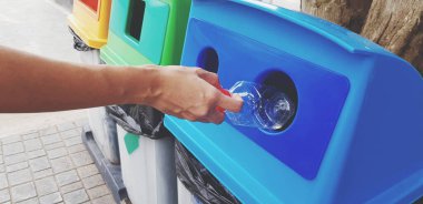 El ele tutuşup plastik su şişesini mavi geri dönüşüm kutusuna, çöp kutusuna ya da çöp kutusuna antika tonda dökün. Temizlik alanı ve kullanılan geri dönüşüm kavramı