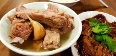 Çin restoranı Singapur 'da ahşap masada kaynamış domuz kemiği ve sarımsak çorbası. Bak kut teh adlı bu yemek ünlü yemek ve lezzetlidir. Seçici odak