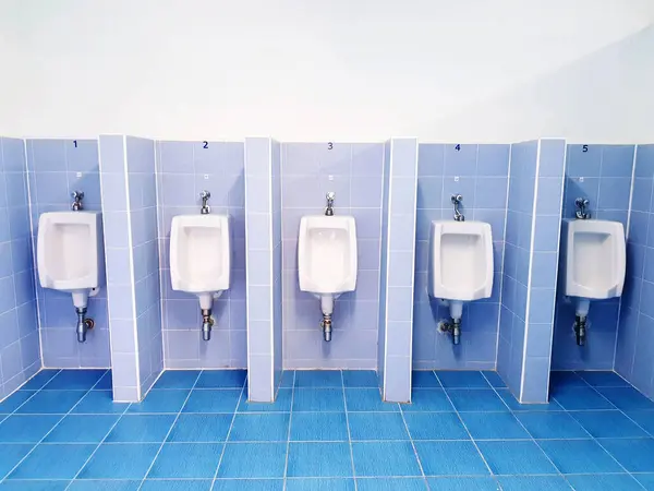 Five white urinal on blue wall with tile in men toilet or Public rest room. Object, Interior design and Sanitary ware concept