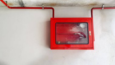 Yangın söndürücü ya da yangın musluğu solda fotokopi alanı olan duvarda kırmızı su borusu ya da boru hattı asılı. İtfaiyecilerin nesli tükenmek için kullandığı bir araç..