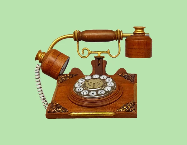 Vintage phone, Wooden telephone isolated on green pastel color background with clipping path. Communication and Old technology in retro style. This object made by wood with a redesign concept