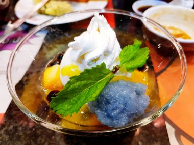 Tatlı dükkanındaki cam kasede tatlı pilavlı olgun mangolu dondurmayı kapat..