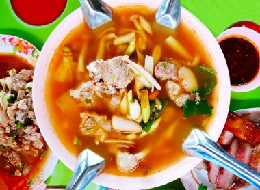 Tom yum ya da Tom Sab domuz eti, ızgara domuz boynu ve yerel bir lokantada Tayland yemeği tarzında masada domuz kuzu eti. Et ve kaşıkla baharatlı çorba. Asya ya da Tayland menüsünde yemek..