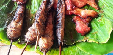 Tayland yerel yemek restoranında satılık muz yaprağı üzerinde ızgara yayın balığı veya kızarmış domuz ve tavuk göğsü. Lezzetli, Diyet ve Sokak Gıda Pazarı 