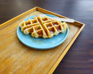 Kafede mavi tabakta bal soslu waffle. Fotokopi alanı olan tatlı fırın.