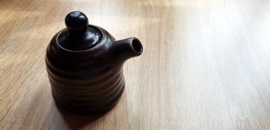 Siyah seramik sürahi ya da ahşap masaya fotokopi alanı konan bardak çayı. Sigle nesnesi, Japonya stili bulaşık takımı, Tasarım ve Konteynır konsepti.