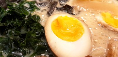 Ramen şehriyesini yosunla kapat, domuz eti dilimleri ve yarım haşlanmış yumurtaları restoranda sıcak miso çorbasına koy. Lezzetli Japon yemeği konsepti ve seçici olarak yumurtaya odaklanma.