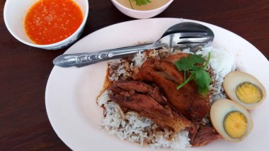 Pirinçli haşlanmış yumurta ve ekşi soslu domuz budu ve ahşap zemin üzerinde tatlı çorba. Tayland ya da Tbailand 'daki meşhur yemek..