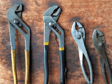 Ahşap arka planda ingiliz anahtarı ve kerpeten çok farklı boyutlarda. Tamir ve bakım makinesi veya motor konsepti için tahta paneldeki araç ve nesne.