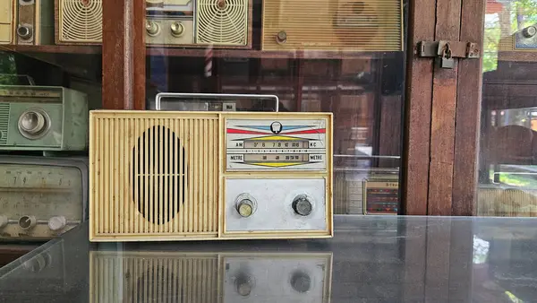 Vitrin arkası cam rafa konmuş klasik bir radyo. Retro ya da elektronik cihaz ve 80 'lerden 90' lara kadar eski tarz. Koleksiyon Grubu