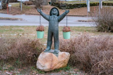 Şapkalı küçük bir çocuk heykeli gökyüzüne bakıyor, çocuk parkı, Hattfjelldal, Norveç - 26 Kasım 2022