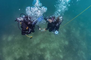 Usta dalgıç ve dalış öğrencisi sığ sularda dalış eğitiminden sonra yükselmeye hazırlanıyor. Basınç düşmesi için dalış durağında bekliyorlar. Hazır olun..