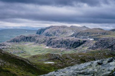 İskandinav Dağları 'ndaki yüksek rakımlı dağ arazisinin manzarası. Ağır koyu mavi bulutlar. Norveç 'te yürüyüş rotası, Krutvatnet bölgesi
