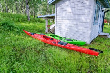 İki kano - kırmızı ve yeşil olanlar barakanın yanındaki yeşilde. Yaz tatili dağlarda, İsveç 'te, Laponya' da
