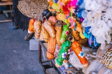 Colorful wooden penis shaped souvenirs with bottle openers are hanging for sale in a traditional Balinese shop near Tanah lot temple