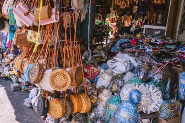 Tanah tapınağının yakınlarındaki canlı bir pazar yerinde asılı duran renkli, yuvarlak raket torbaları, Bali zanaatkarlığı ve kültür mirası sergileniyor.