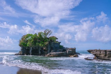 Tanah tapınağındaki kayalık kıyılara vuran dalgalar Endonezya, Bali 'deki küçük bir adanın Hindu hac alanı doğal güzelliğin ve manevi öneminin resimsel bir sahnesini oluşturuyor.