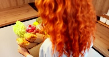 Video filmed from above, a young lady puts the basket of vegetables on the table which is very colorful and beautiful. High quality 4k footage