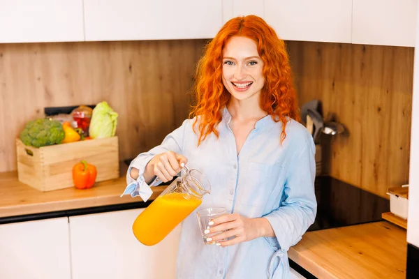 Beautiful smiling healthy woman with juice in her hands while preparing vegan food. Proper nutrition. High quality photo