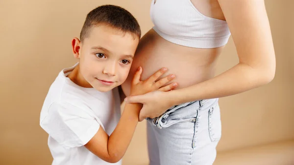 Hijo Guapo Está Escuchando Hermosa Madre Embarazada Barriga Sonriendo Niño — Foto de Stock
