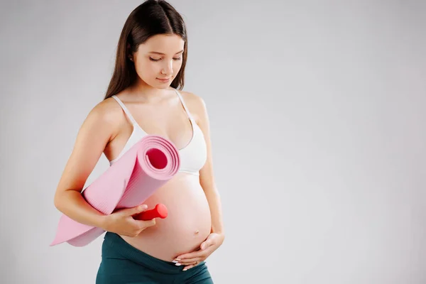 Mujer Joven Embarazo Temprano Con Estera Enrollada Debajo Del Brazo — Foto de Stock