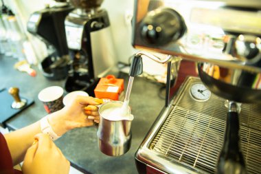 Kahve makinesinde çalışan barmen, kapuçino ya da latte yapan barmen, kafe tezgahında kahve hazırlayan barmen. Yüksek kalite fotoğraf