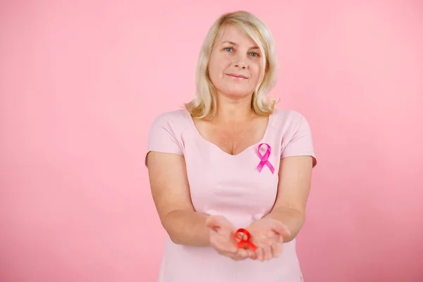 stock image Happy Woman with pink ribbon, great for prevention breast cancer concept. He holds out a ribbon to the camera. High quality photo