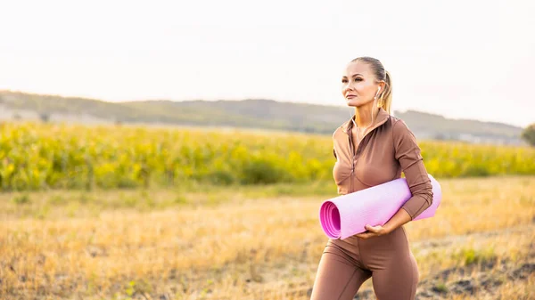 Genç Kadın Yoga Minderini Elinde Tutuyor Sahada Koşuyor Sağlıklı Yaşam — Stok fotoğraf